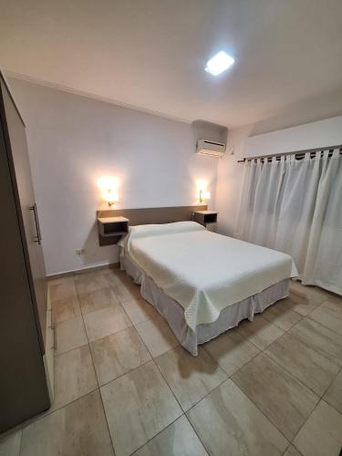 a bedroom with a large bed and two night stands at Puerto Termas in Colón