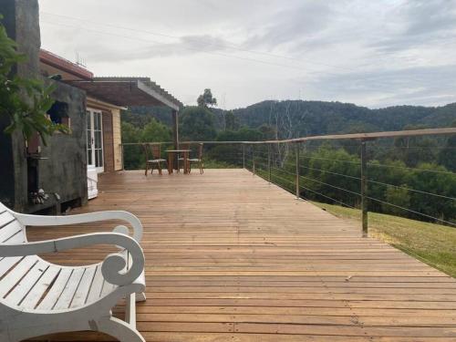 a wooden walkway with a bench on a deck at Valley View in Possum Brush