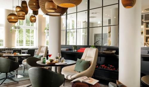 a restaurant with tables and chairs and windows at Holiday Inn Dresden - Am Zwinger by IHG in Dresden