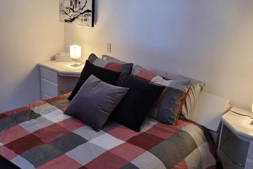 ein Schlafzimmer mit einem Bett mit Kissen darauf in der Unterkunft Le Repaire Secret in Saint-Donat-de-Montcalm