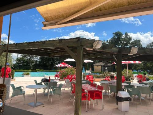 un patio avec tables et chaises et une piscine dans l'établissement Mobil Home Titania, à Villemur-sur-Tarn