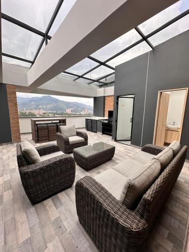 a living room with couches and chairs and a large window at Aluna Apto/ Wellness and Enjoy in Sabaneta