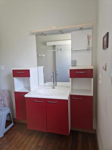a bathroom with a red sink and a mirror at Сocon bien douillet in Saint-Denis-dʼOléron