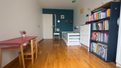 une chambre avec une table et une étagère avec des livres dans l'établissement Appartement comfortable 19e, à Paris
