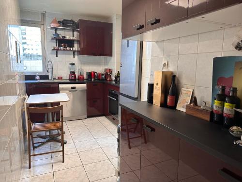 une cuisine avec un comptoir et une table à l'intérieur dans l'établissement Appartement comfortable 19e, à Paris