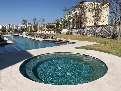 a pool of water with benches in a park at CASA preciosa en SAN MIGUEL con alberca, 6PAX 4bed in San Miguel de Allende