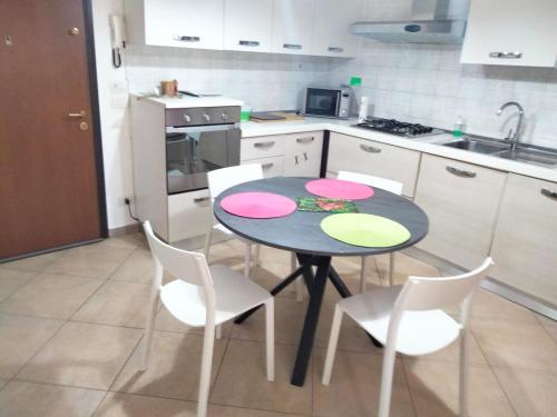 a kitchen with a table and chairs with pink and green plates on it at Stefy House in Lastra a Signa