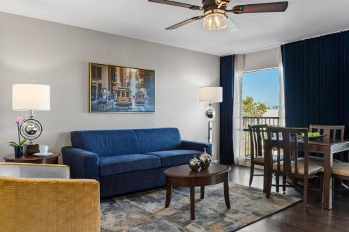 a living room with a blue couch and a table at The Suites at Fisherman's Wharf in San Francisco