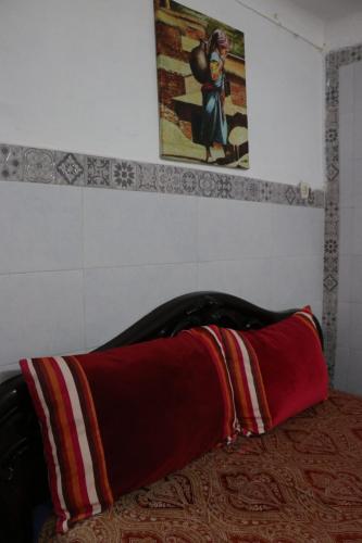 a red blanket laying on a bed in a room at White And Blue in Essaouira