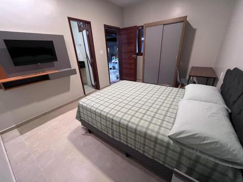 a bedroom with a bed and a flat screen tv at Casa para aluguel de temporada in Crato