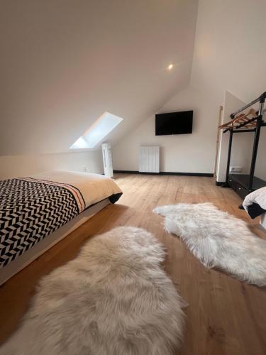 a bedroom with two white furry rugs on the floor at Évasion centre ville Avranches proche du mont saint Michel in Avranches