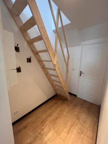 a attic room with a wooden staircase and a door at Évasion centre ville Avranches proche du mont saint Michel in Avranches