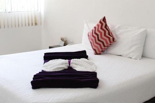 a white bed with three towels on top of it at Rancho Macloy Hotel Spa & Social Events in Yautepec