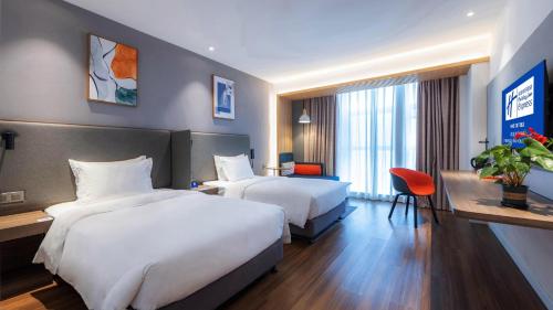 a hotel room with two beds and a desk at Holiday Inn Express Chengdu Wuhou New City by IHG in Chengdu