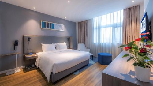 a hotel room with a bed and a large window at Holiday Inn Express Chengdu Wuhou New City by IHG in Chengdu