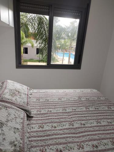 a white couch in a room with a window at Apartamento confortável e com piscina em São Paulo in Sao Paulo