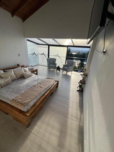 a large bedroom with a large bed and a balcony at Hotel Campestre el Volcan De Guatape in Guatapé