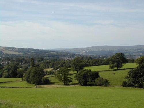 a green field with trees in the distance at Chevin End Guest House in Otley
