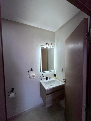a bathroom with a sink and a mirror at Appartement a zenata ain-harrouda casablanca in Mohammedia