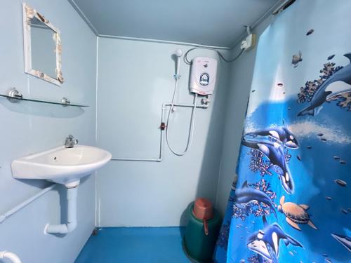 a bathroom with a sink and dolphin shower curtain at Beach Shack Tioman - Beachfront Seaview in Tioman Island