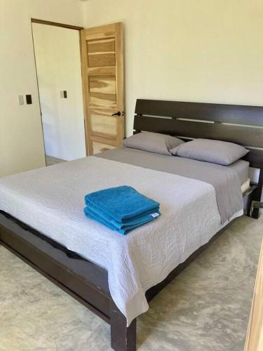 a bedroom with a bed with two towels on it at Finca Makai, rodeado de naturaleza, 10min a Montezuma in Montezuma