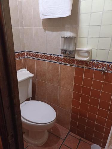 a bathroom with a toilet and a towel at Posada El Palomar in Pátzcuaro