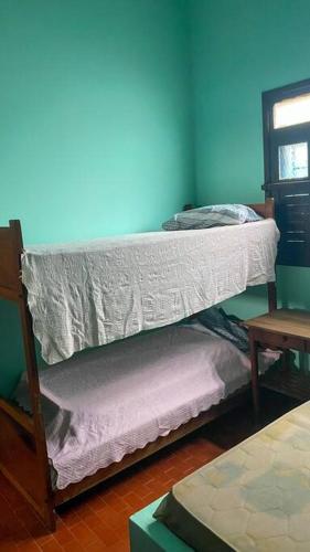 a bunk bed in a room with a blue wall at Casa em Praia Grande - Fundão in Fundão