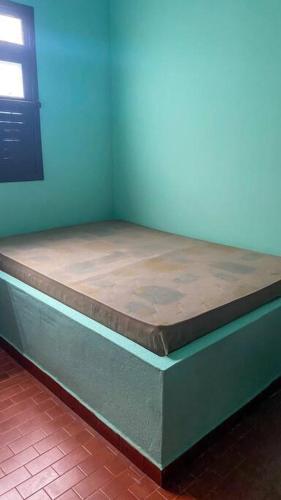a bed sitting in a corner of a room at Casa em Praia Grande - Fundão in Fundão