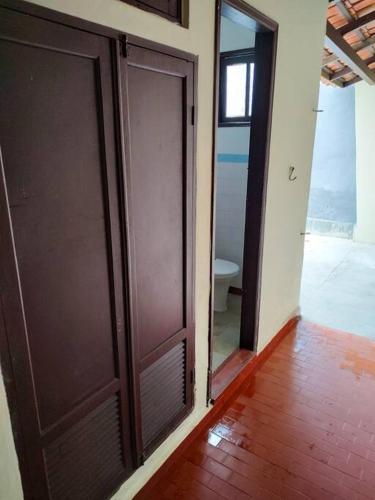 an empty room with two doors and a toilet at Casa em Praia Grande - Fundão in Fundão