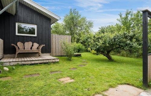 a bench sitting on a deck in a yard at Gorgeous Home In Hjerm With Kitchen in Hjerm
