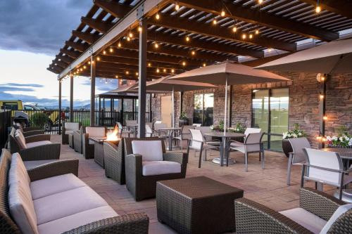 an outdoor patio with chairs and tables and umbrellas at Holiday Inn Express Belgrade-Bozeman Area by IHG in Belgrade