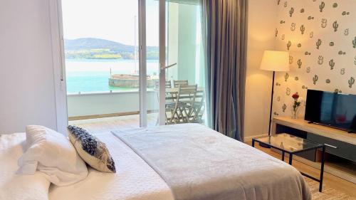 a bedroom with a bed and a view of the ocean at The Cliffs A Ribeira - Llas in Foz