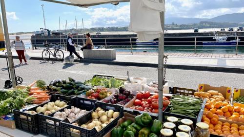 a farmers market with fruits and vegetables on a boat at The Cliffs A Ribeira - Llas in Foz