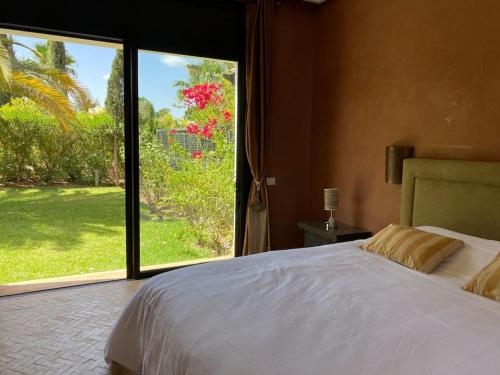 a bedroom with a large bed and a large window at Luxueuse villa Proche Agadir et Taroudant pour 6 pers Piscine Privée sans vis à vis in Agadir