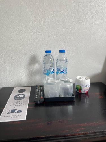 two bottles of water and a remote control on a table at Villa Merry Lao Ban Aphay in Luang Prabang