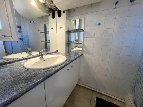 une salle de bain avec un lavabo et un miroir dans l'établissement BANYULS-SUR-MER, duplex 4 pers, garage, proche plage - FR-1-309-276, à Banyuls-sur-Mer