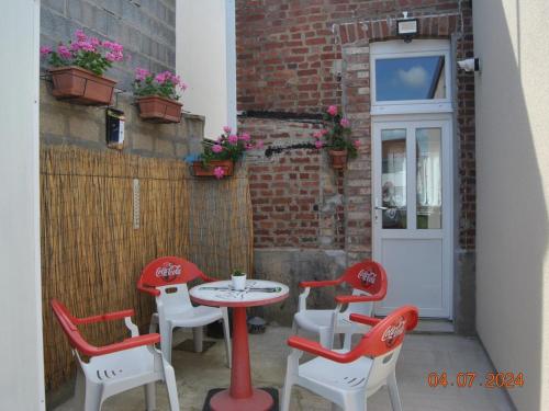 d'une terrasse avec une table, des chaises et une porte. dans l'établissement Charmant Duplex avec Jardin Privé, à 20km des Caps - FR-1-376-116, à Rinxent