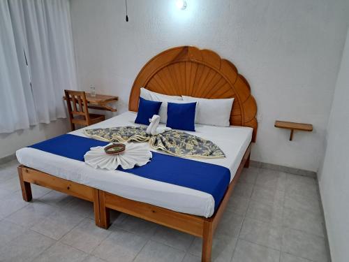 a bedroom with a large bed with a wooden headboard at Hotel Quinta Paraiso in Cocoyoc