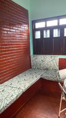 a small room with a bench next to a brick wall at Casa em Praia Grande - Fundão in Fundão