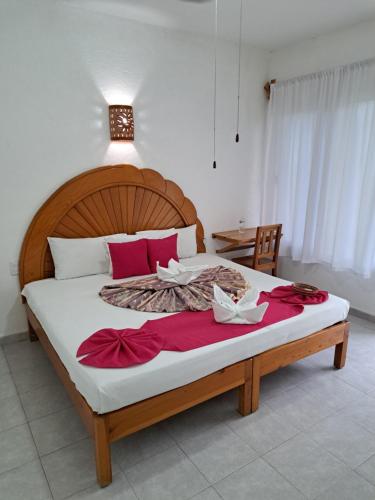 a bedroom with a large bed with red pillows at Hotel Quinta Paraiso in Cocoyoc