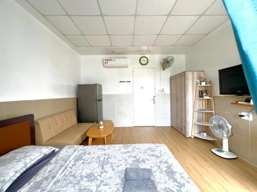 Un dormitorio con una cama, un sofá y un televisor. en Căn Studio Áp Mái Full Nội Thất - Gần TTTM Aeon Tân Phú, en Ho Chi Minh