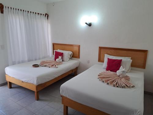 two beds in a hotel room with towels on them at Hotel Quinta Paraiso in Cocoyoc