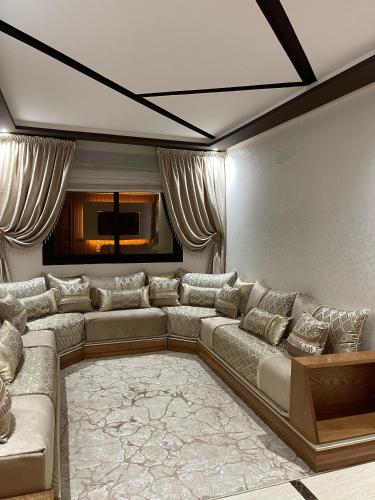 sala de estar con sofá grande y alfombra en Luxury appartement with Private Parking For families only, en Tánger