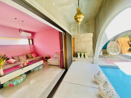 a room with pink walls and a swimming pool at Ayurwellness Resort Okinawa in Motobu