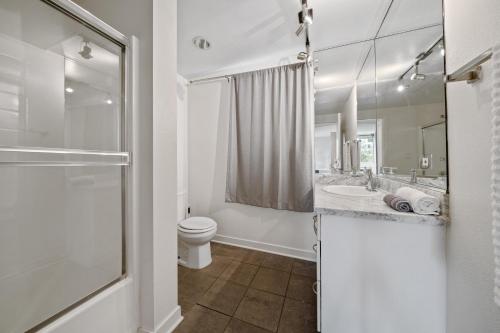 Un baño con inodoro, lavabo y ducha. en Le Reve , 5 min to the beach Luxury Condo, en Los Ángeles