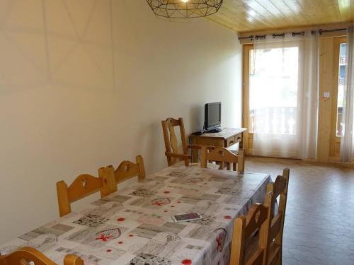 une salle à manger avec une table avec des chaises et une télévision dans l'établissement Appartement rénové 2 pièces, 5 pers, WiFi, garage, navette, centre Les Gets - FR-1-802-18, aux Gets
