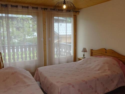 une chambre avec un lit et une grande fenêtre dans l'établissement Appartement rénové 2 pièces, 5 pers, WiFi, garage, navette, centre Les Gets - FR-1-802-18, aux Gets