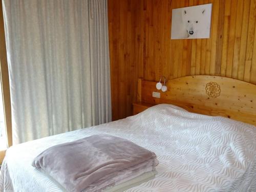 une chambre avec un lit et une horloge au mur dans l'établissement Spacieux 3 Pièces - Centre des Gets - Garage, Wifi & Linge Inclus - Proche Commerces & Remontées - FR-1-802-21, aux Gets