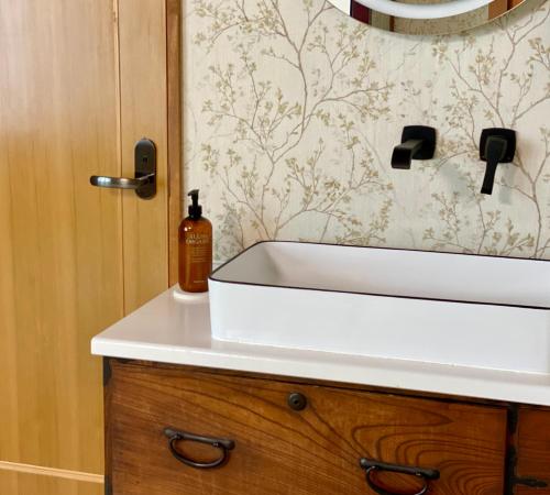 a bathroom sink with a bottle of soap on it at Togari Inn Suites in Iiyama