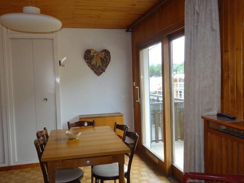 une salle à manger avec une table et un cœur sur le mur dans l'établissement À Louer Les Gets: 2 Pièces, 4 Pers, Centre, Wifi, Draps et Serviettes Inclus - FR-1-802-23, aux Gets